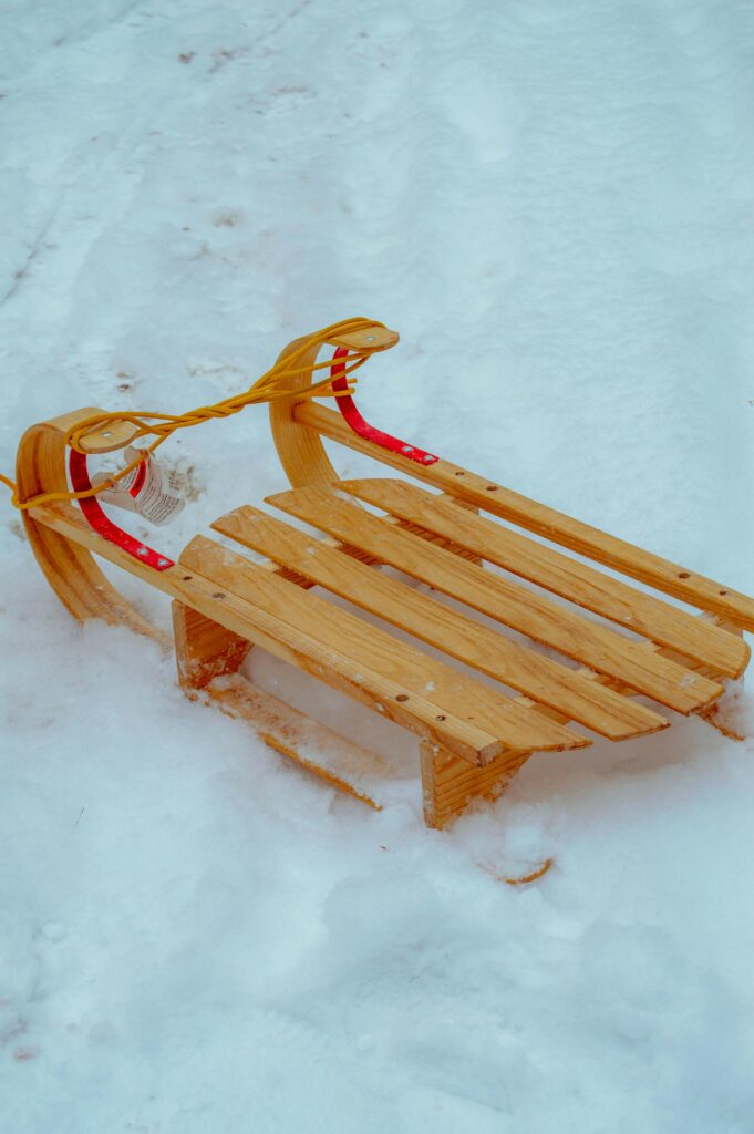 A traditional wooden sled rests on a snow-covered landscape, capturing winter's charm.