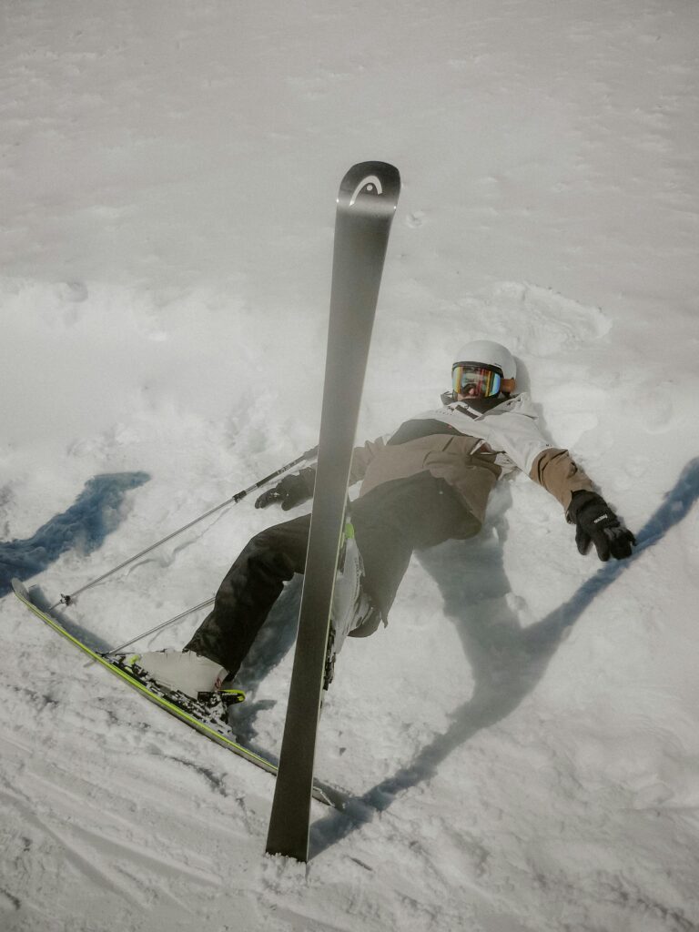 Ski enthusiast humorously slips on a snowy slope, adding a light-hearted touch to winter sports.