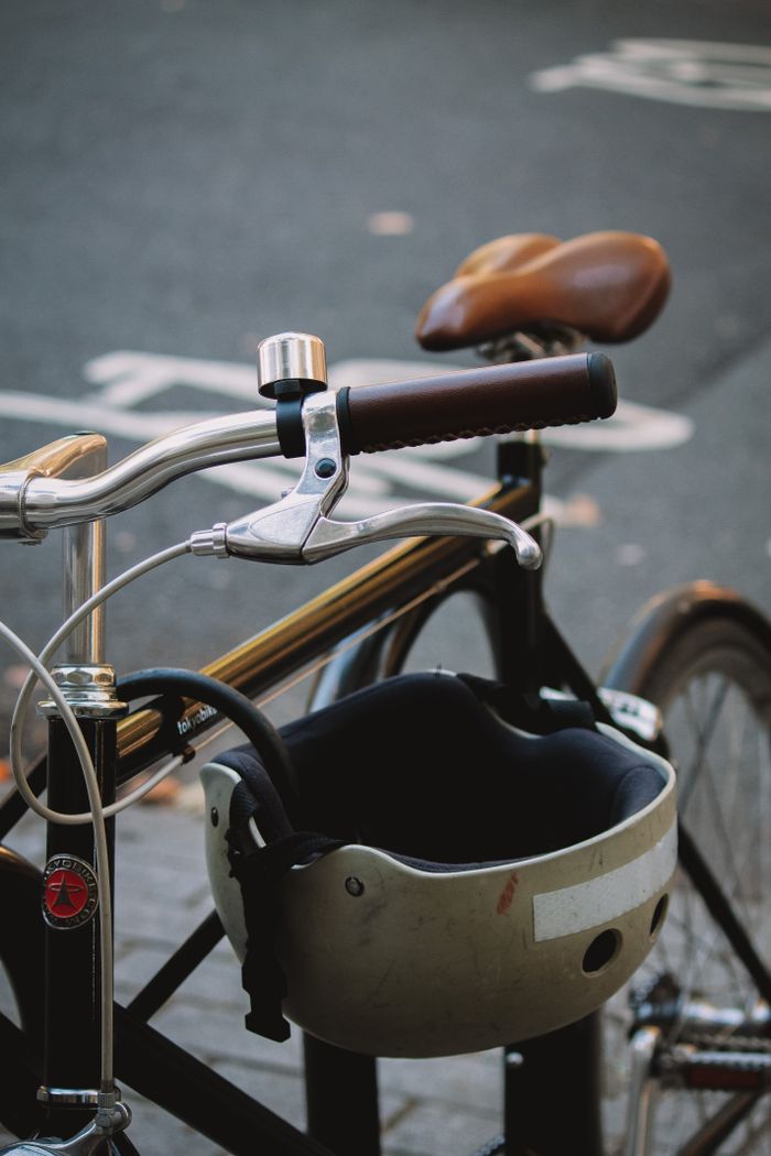 Detailed view of bicycle handlebars and helmet on a London street captured in daylight.