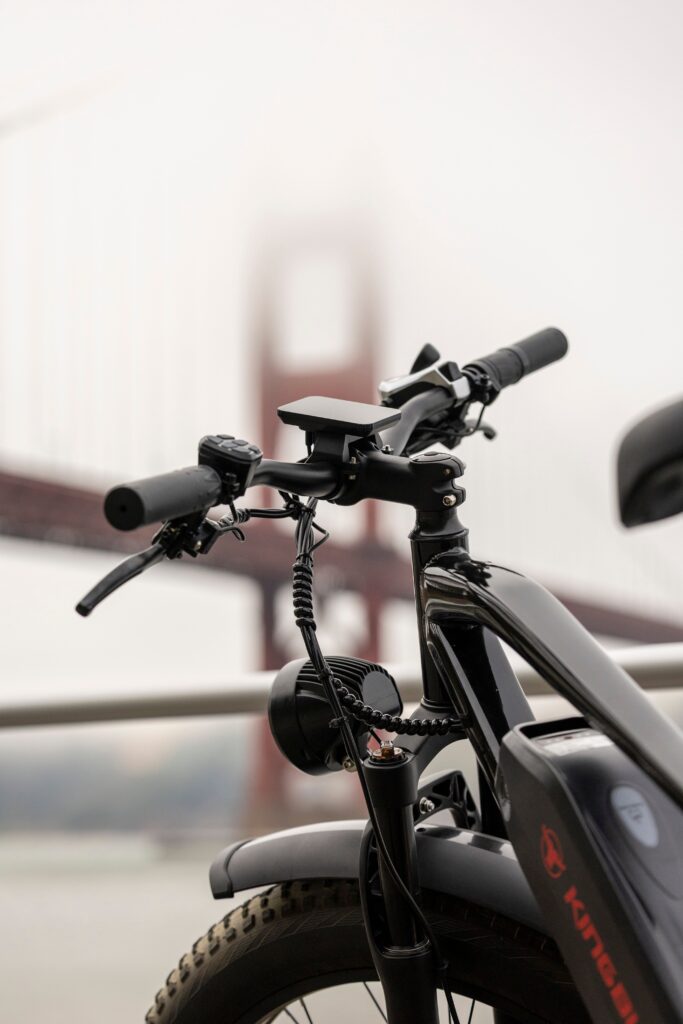 Electric bike parked near the iconic Golden Gate Bridge on a foggy day.
